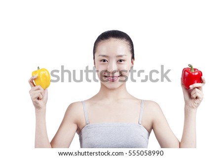 	young woman holds two bell pepers	