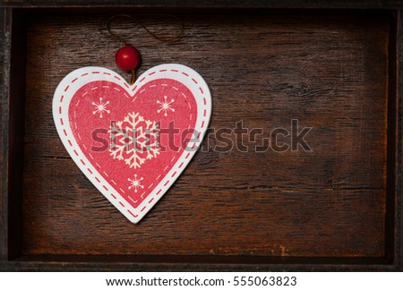 red heart with snowflakes on a beautiful wooden background, top view. Blank space for text and design
