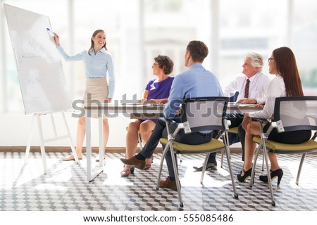 Cheerful business coach explaining strategy Royalty-Free Stock Photo #555085486