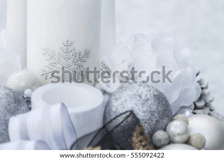 Beautiful winter decorative plate decorated with candles, bulbs, flowers, beads and ribbons pictured on snow. Plate is created in white and silver colors with little additions of black and gold.