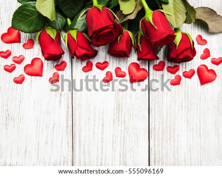 Red roses  with  hearts  on a old wooden table Royalty-Free Stock Photo #555096169