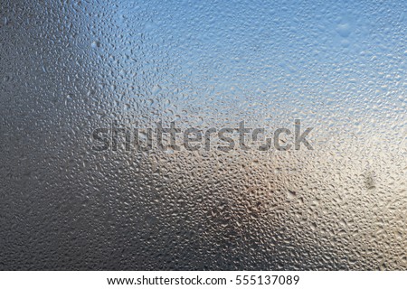 Closeup detail of Moisture condensation problems, hot water vapor condensed on the cold window glass, macro Royalty-Free Stock Photo #555137089