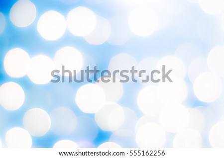 Soft colorful bokeh background. Luminous garlands of electric lights. Copy space to add text. Saturated colors. Blurry abstraction. Gentle yellow, blue tone. Dark night. Festive party.