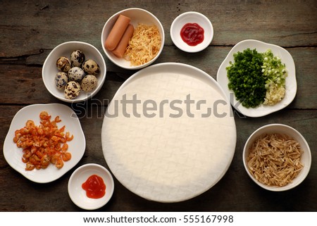 Vietnamese street food, baked girdle cake, a famous snack food make from rice paper, onion, shrimp, sausage, quail egg, chili sauce, people also call this eating is Vietnam pizza
