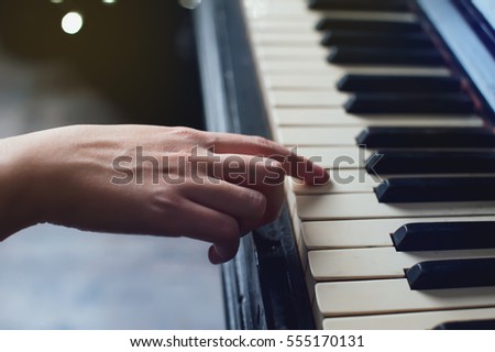 The girl plays piano,close up , white and black keyboard