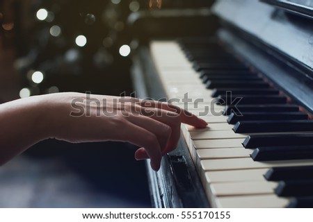 The girl plays piano,close up , white and black keyboard