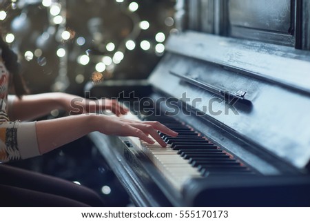 girl playing on an old piano. Beautiful blur background