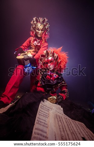 Musicians in Venetian masquerade costumes. Romantic guitarist.