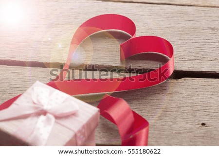 heart red ribbon and gift valentine concept on wooden texture.