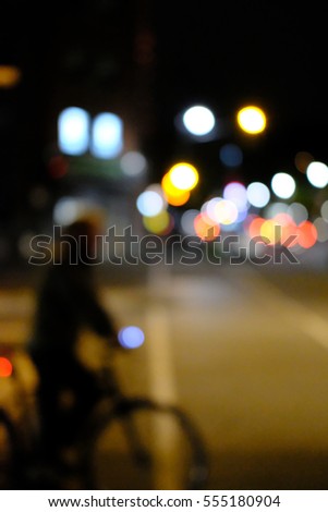 Abstract view of a city commuter on a bicycle at a junction at night.