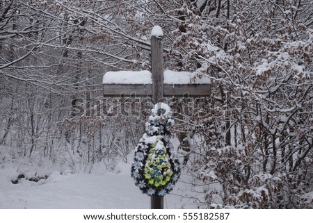 Sign of faith. A wooden cross in a snowy forest.