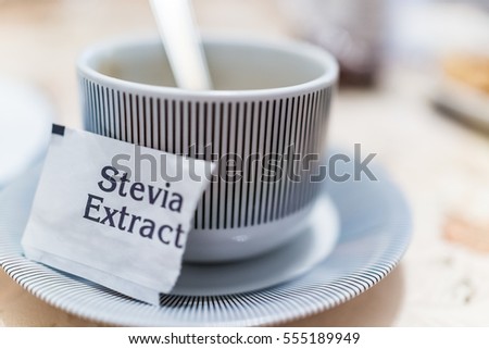 Small coffee cup on plate with stevia extract packet
