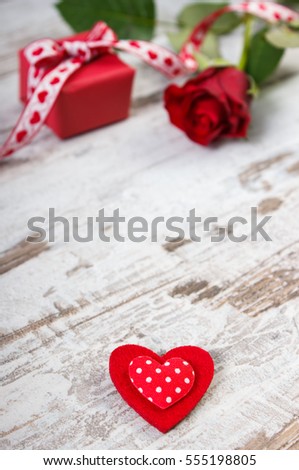 Valentine red heart, wrapped gift with ribbon and rose on old wooden background, decoration for Valentines Day, copy space for text