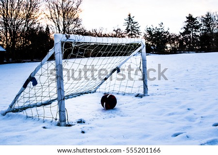 Football in snow with a ball in the net