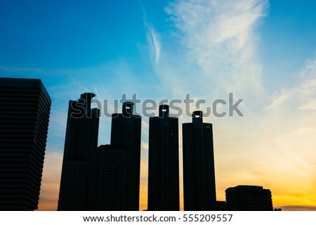 Silhouette Business district cityscape from park,Benchakitti Park in Morning with cityscape reflection, Bangkok Thailand.