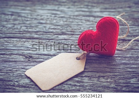 red heart shape with blank paper tag on wooden table background ,vintage color tone,Image for Happy valentine day concept.