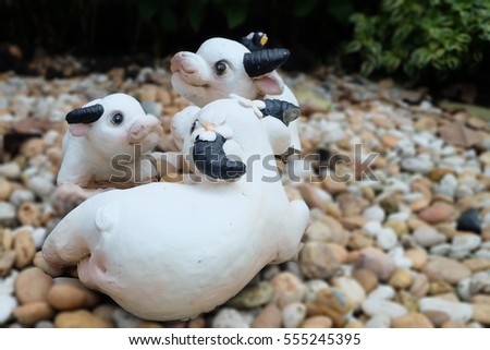 Clay sculpture buffalo family with mynas on pebbles ground 