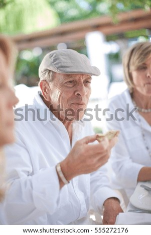 Older friends eating together outdoors