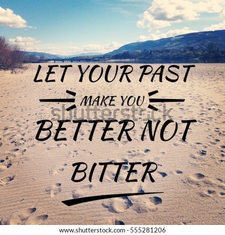 "Let your past make you better not bitter". Inspirational text on sand of scenic landscape with footprints in sand, calm water, bright blue sky with clouds, mountains, bridge and reflections on water.
