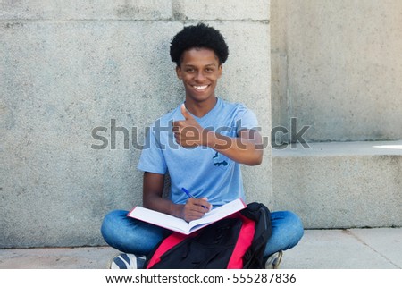 Cool african young adult male student showing thumb up