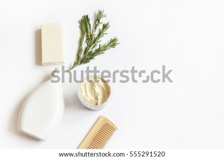 Wooden comb, rosemary, shampoo bottle, baby soap, mask of cosmetic white kaolin and toy horse. Natural organic bath products. Flat lay photo, top view. Photography for design site and beauty blog
