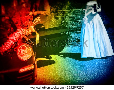 Arrangement flower bouquet on black German wedding car. Bride in white dress and groom getting out of the car, image for wedding concept, bridal blogs. Image with retro filter, selective focus