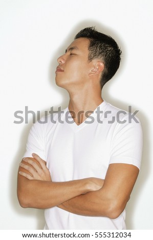 Young man looking away, arms crossed.