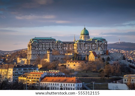 Budapest, Hungary - The famous Buda Castle (Royal Palace), St. Matthias Church and Fishermen's Bastion at sunset on a nice winter afternoon taken from Gellert Hill Royalty-Free Stock Photo #555312115