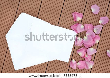 Empty blank card and envelope with rose flower on wooden.