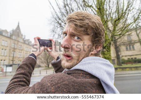 
Man making photo with his mobile on the street
Young man photographing on the street