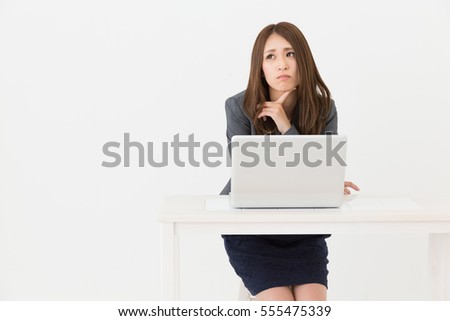 Beautiful young asian businesswoman using laptop,think,