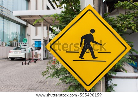 street sign / symbol of beware people cross street at bangkok in thailand