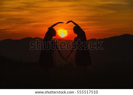 Silhouette of hands in love above the dam at the sky sunset.,silhouette people and view of mountains at sunrise, winter landscape with foggy hills at sunrise.
