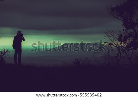 Vintage color silhouette shadow of traveler photography a mountain landscape under rainy clouds  