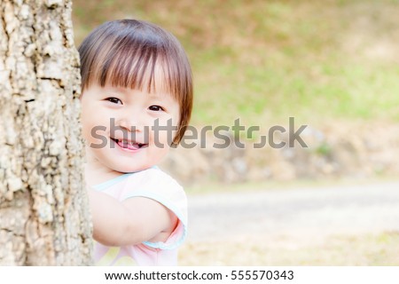 Charming asian little girl was playing happy smile in the park soft focused.