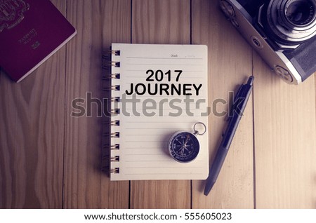 Top view of 2017JOURNEY written on the notebook,travel planning concept.note book,compass,passport,film camera on the wooden desk.