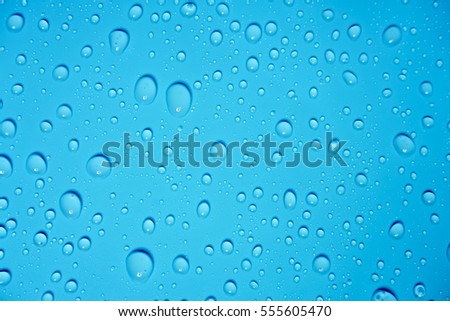Selective focus of water drops on blue background.