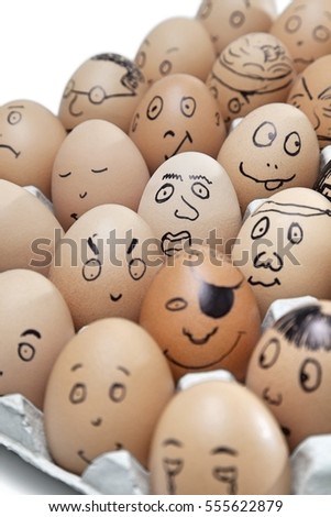 Various facial expressions painted on brown eggs arranged in carton