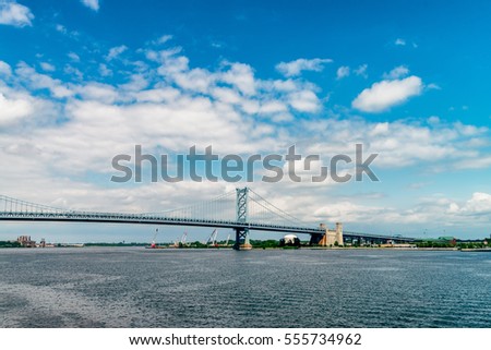 View on Delaware river and Benjamin Franklin Bridge. Bridge â?? is a suspension bridge across the Delaware River connecting Philadelphia, Pennsylvania, and Camden, New Jersey. Vivid, splittoned image.