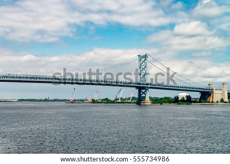 View on Delaware river and Benjamin Franklin Bridge. Bridge â?? is a suspension bridge across the Delaware River connecting Philadelphia, Pennsylvania, and Camden, New Jersey. Vivid, splittoned image.
