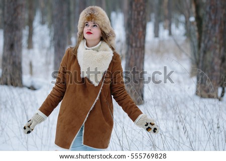 Young pretty woman walking in the winter forest