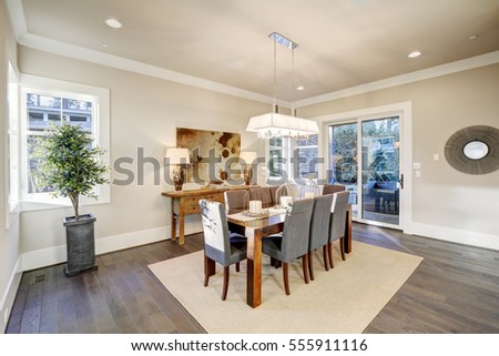 Lovely dining room with rectangular dining table paired with grey high back dining chairs over sisal rug. Northwest, USA




