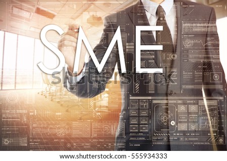 the businessman in the office is writing on the transparent board word associated with the SME