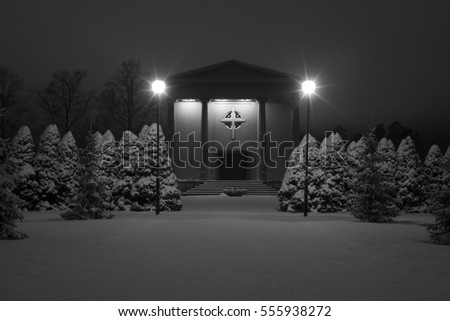 Church chapel at cold winter night in Sweden Scandinavia. Beautiful black and white photo. Calm, peaceful image. Nice picture with snow and lights at cemetery.