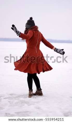 Glamorous young girl dancing on frozen lake