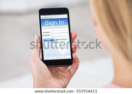 Close-up Of Woman Hand Holding Mobile Phone Showing Log In Page