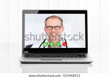 Close-up Of Videoconferencing With Male Doctor On Laptop At Desk Royalty-Free Stock Photo #555968911