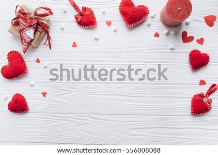Wooden white background with red hearts, gifts and candles. The concept of Valentine Day.
