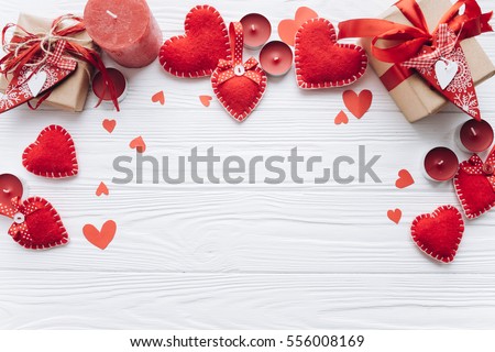 Wooden white background with red hearts, gifts and candles. The concept of Valentine Day. Royalty-Free Stock Photo #556008169