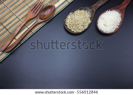 Spoons, forks and ladles Put the rice with jasmine rice made of wood on a black background.